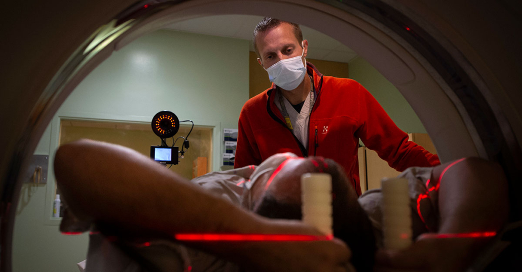 A radiation therapist prepares a patient for a CT scan