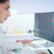 Oncology Data Specialist looking closely at data on a computer screen.